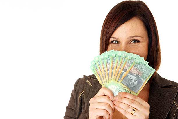 A woman holds a stack of Australian dollars